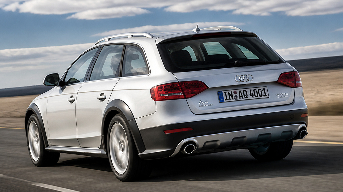 Carro Audi A4 Allroad Quattro prata a circular numa estrada com paisagem desértica ao fundo.
