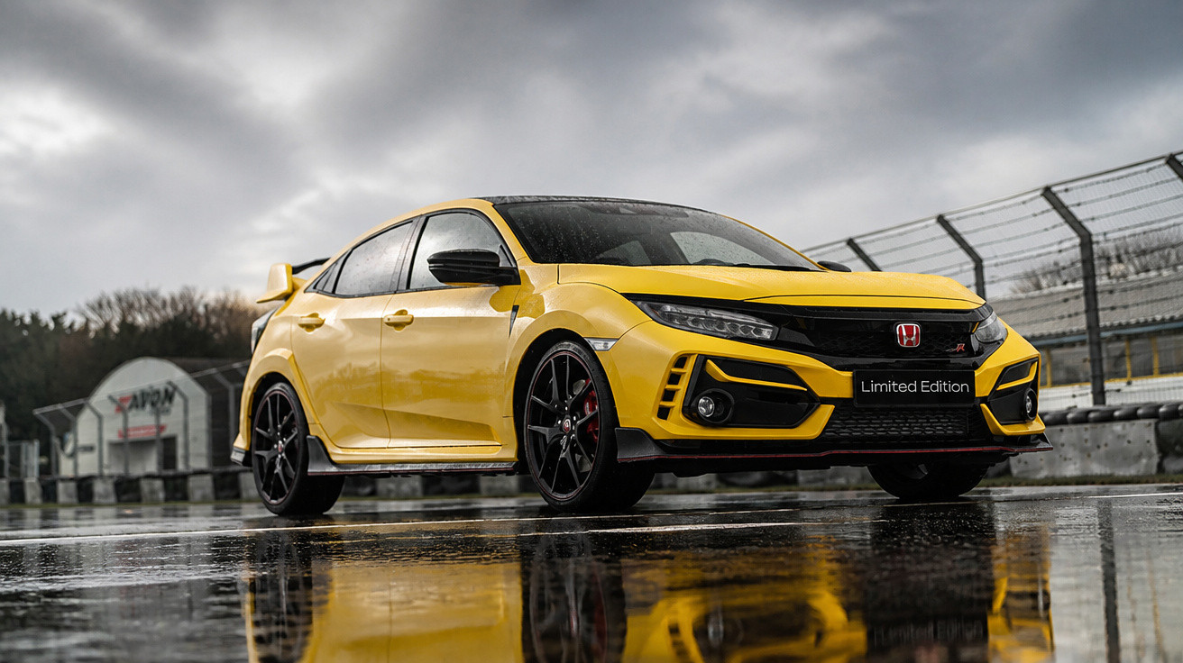Carro desportivo amarelo Honda Civic Limited Edition estacionado em pista molhada com céu nublado.