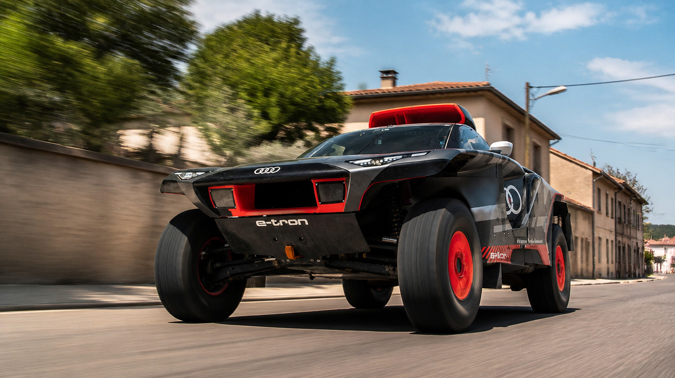 Carro de corrida Audi e-tron preto e vermelho a alta velocidade numa estrada urbana.