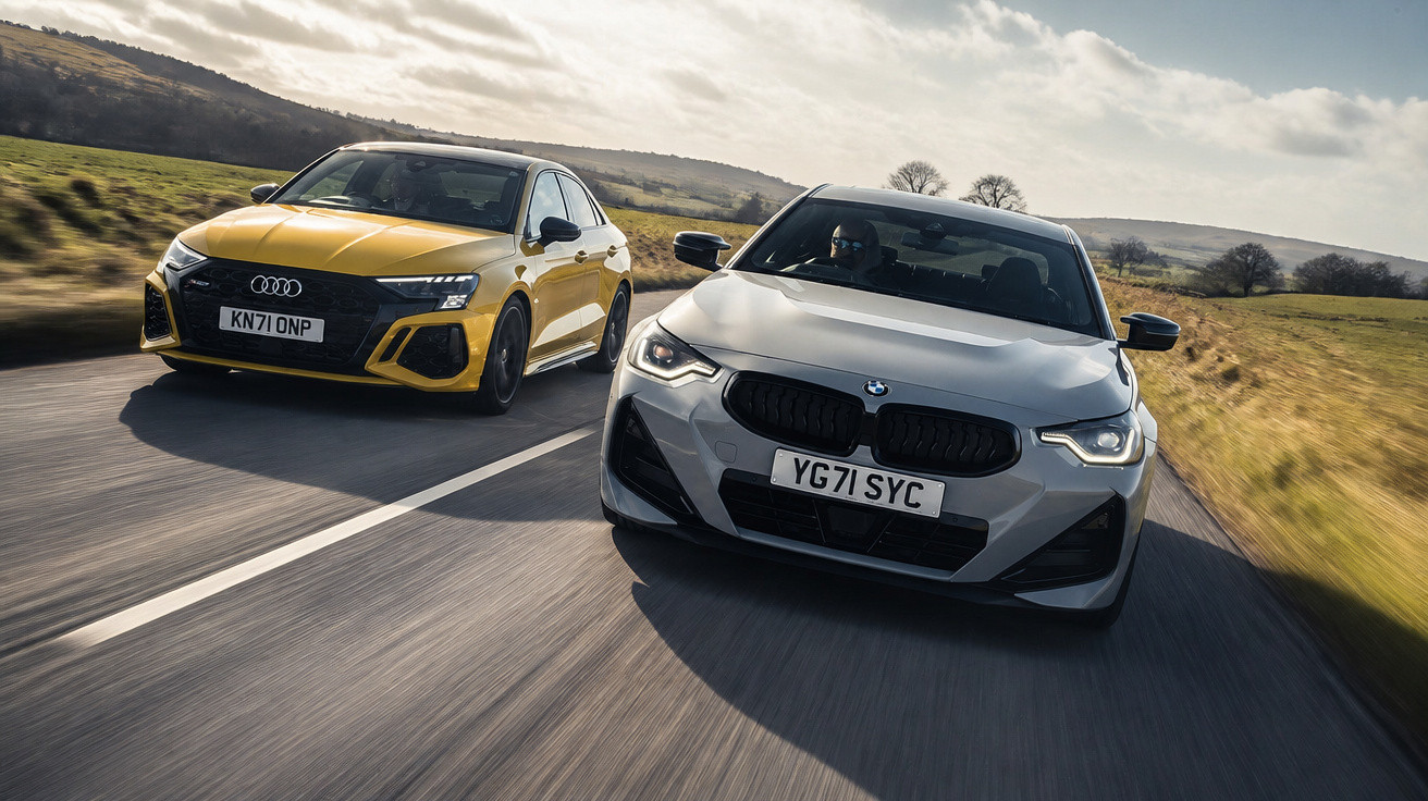 Dois carros desportivos, um Audi amarelo e um BMW cinzento, a circular lado a lado numa estrada rural.