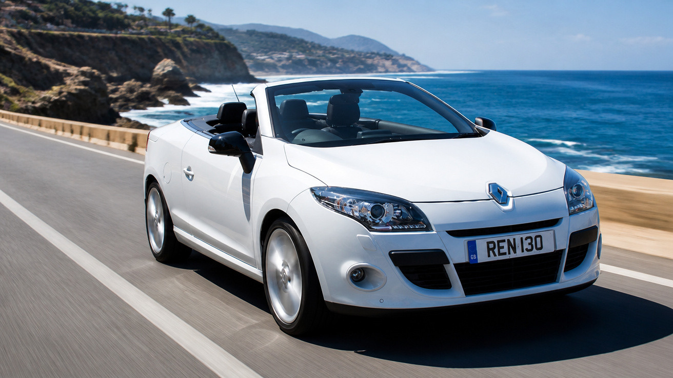 Carro conversível branco a circular numa estrada costeira com mar e falésias ao fundo.